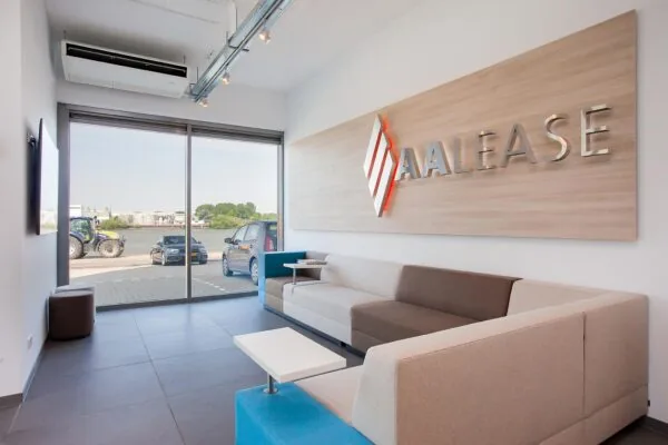 Moderne wachtruimte van AA Lease met uitzicht op geparkeerde auto's en kanaal aan de Laan der Verenigde Naties.